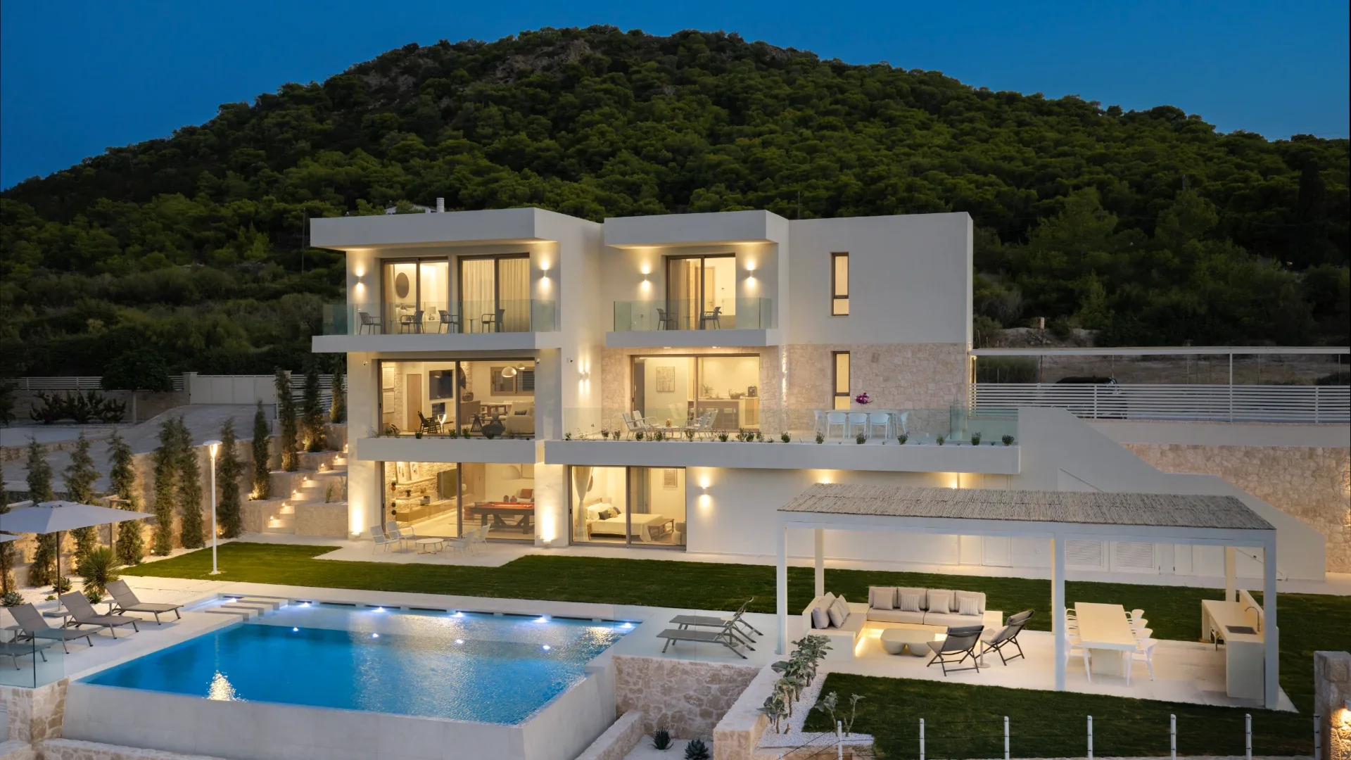 Kyrelia Villa illuminated beside the pool at dusk